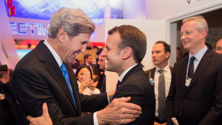 John Kerry and Emmanuel Macron embracing