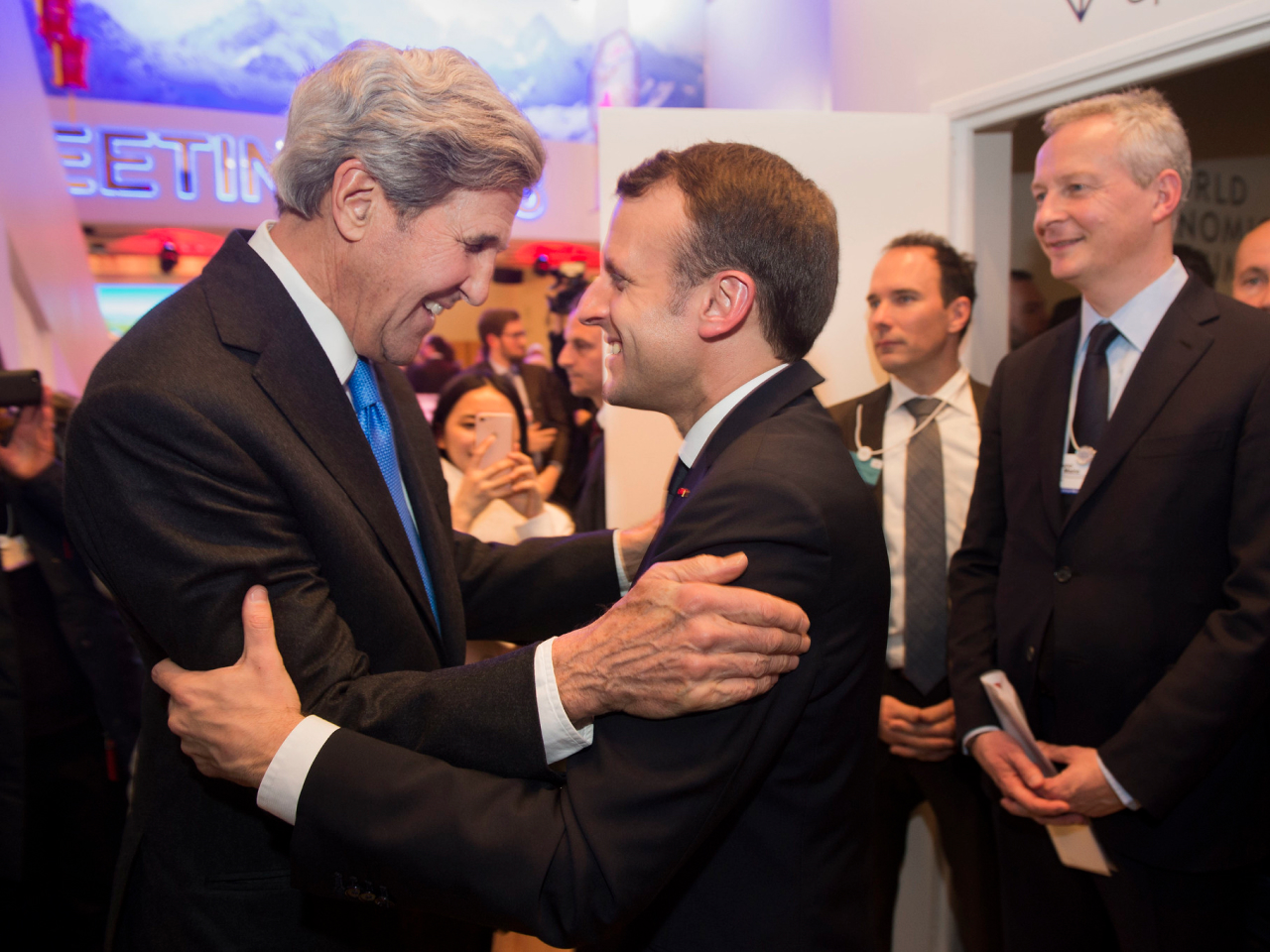 John Kerry and Emmanuel Macron embracing