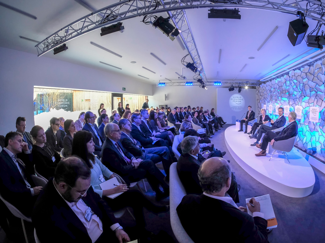 An audience listening to a panel on stage